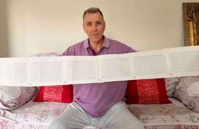 Ο Laurence Watkins κρατώντας το εξασέλιδο πιστοποιητικό γέννησής του, που αναφέρει το πλήρες όνομά του