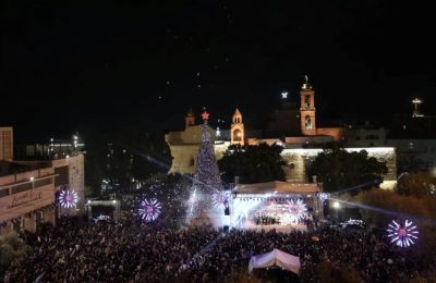 Παλαιστίνιοι συμμετέχουν σε εκδήλωση για το άναμμα του χριστουγεννιάτικου δέντρου στην πλατεία Manger, δίπλα στην Εκκλησία της Γεννήσεως στην Βηθλεέιμ στη Δυτική Όχθη