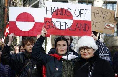 Άνθρωποι κρατάνε σημαίες της Γροιλανδίας σε διαδήλωση διαμαρτυρίας