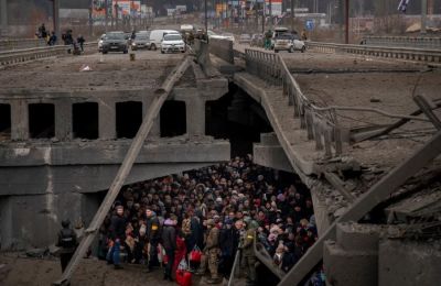 Ουκρανοί πολίτες συνωστίζονται κάτω από κατεστραμμένη γέφυρα, προσπαθώντας να διαφύγουν διασχίζοντας τον ποταμό Ιρπίν, στα περίχωρα του Κιέβου