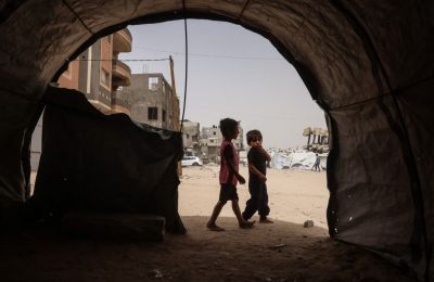 Παιδιά περπατούν ανάμεσα σε αυτοσχέδια καταφύγια για εκτοπισμένους Παλαιστίνιους στο Χαν Γιουνίς, στη νότια Λωρίδα της Γάζας (Photo by Bashar Taleb / AFP).