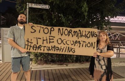 «Διέσωσαν την τιμή μας δύο παιδιά, καλλιτέχνες, ένας Τουρκοκύπριος και η Ιρανή σύντροφός του. Στάθηκαν έξω από τα εγκαίνια με πανό «Stop Normalizing the Occupation, Art Washing»