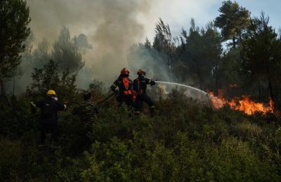Η φωτιά καίει χαμηλή βλάστηση, ενώ η εξέλιξή της παρακολουθείται σε πραγματικό χρόνο με τη χρήση drone από το επιχειρησιακό κέντρο της Πυροσβεστικής.