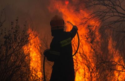 Η πυρκαγιά μαίνεται σε ξηρά χόρτα άγρια βλάστηση και δέντρα.